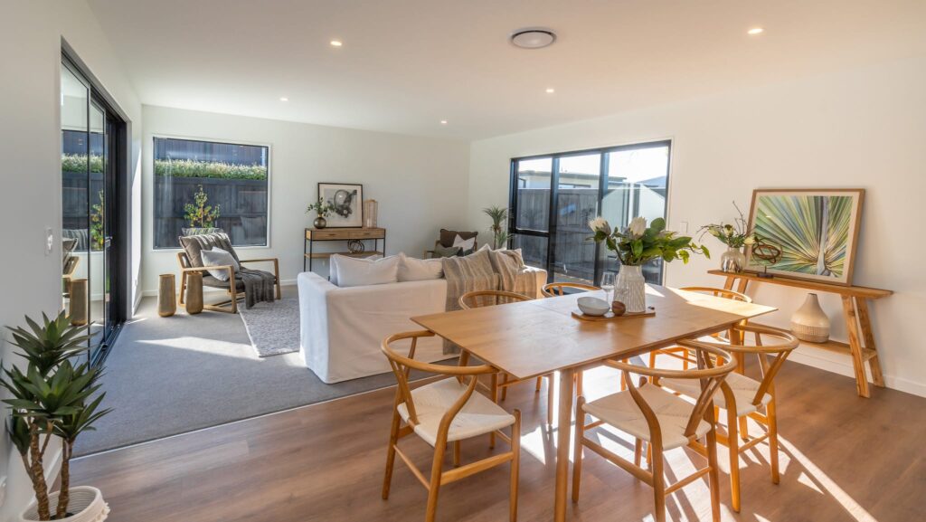 Open plan living and dining area in a modern Hamptons style new home, featuring natural light and contemporary finishes, ideal for families looking for houses to buy or affordable homes for sale.