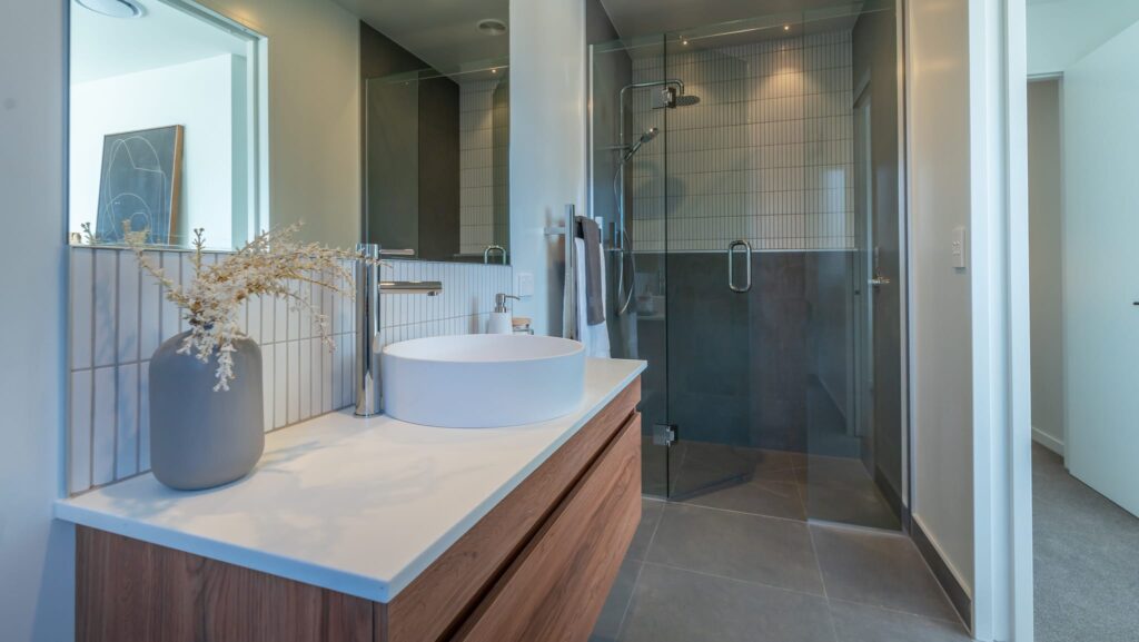 Modern bathroom interior in a new build home featuring a contemporary vanity and walk-in shower, showcasing modern house design for buyers searching for homes for sale, new build houses, affordable homes, architectural homes, or luxury homes.