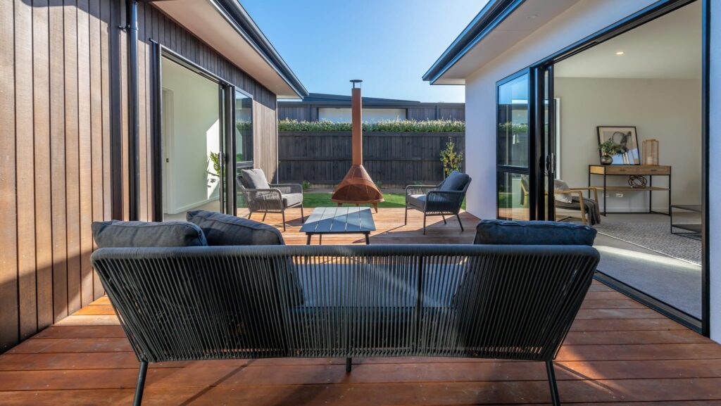 Outdoor courtyard and deck area connecting indoor living spaces in a modern new build Hamptons style home, featuring seamless indoor outdoor flow, ideal for house and land packages and new homes for sale.