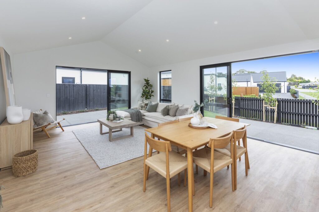 Spacious living and dining area with large windows in a modern new build home designed for comfortable family living.