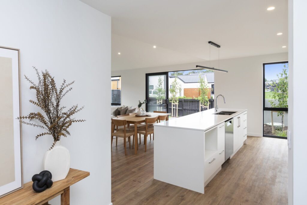 Modern kitchen with island bench and dining space showcasing a new build house with quality finishes.