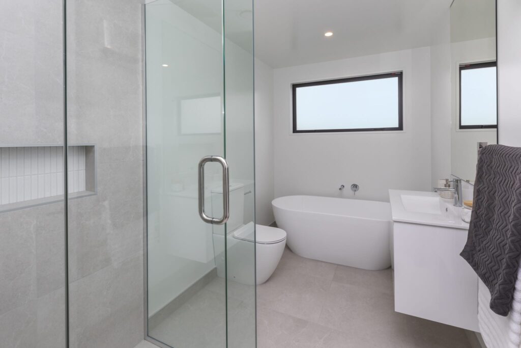 Modern bathroom with freestanding bath and glass shower in a luxury new build home.