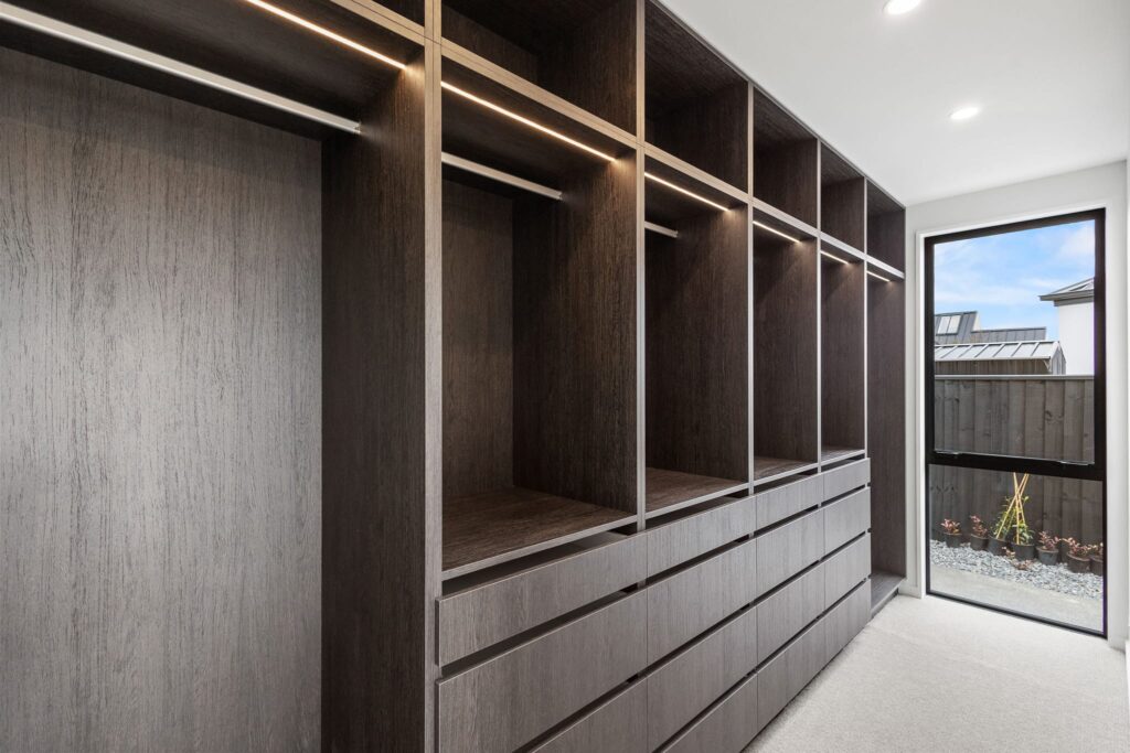 Custom walk in wardrobe with built in storage and LED lighting in a modern new build home, highlighting luxury homes and functional design in houses for sale at Woodleigh Lane.
