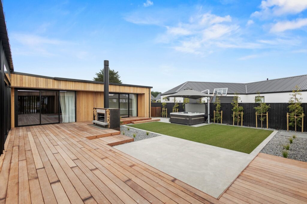 Contemporary outdoor living area of a new build house featuring landscaped grounds and modern home design.
