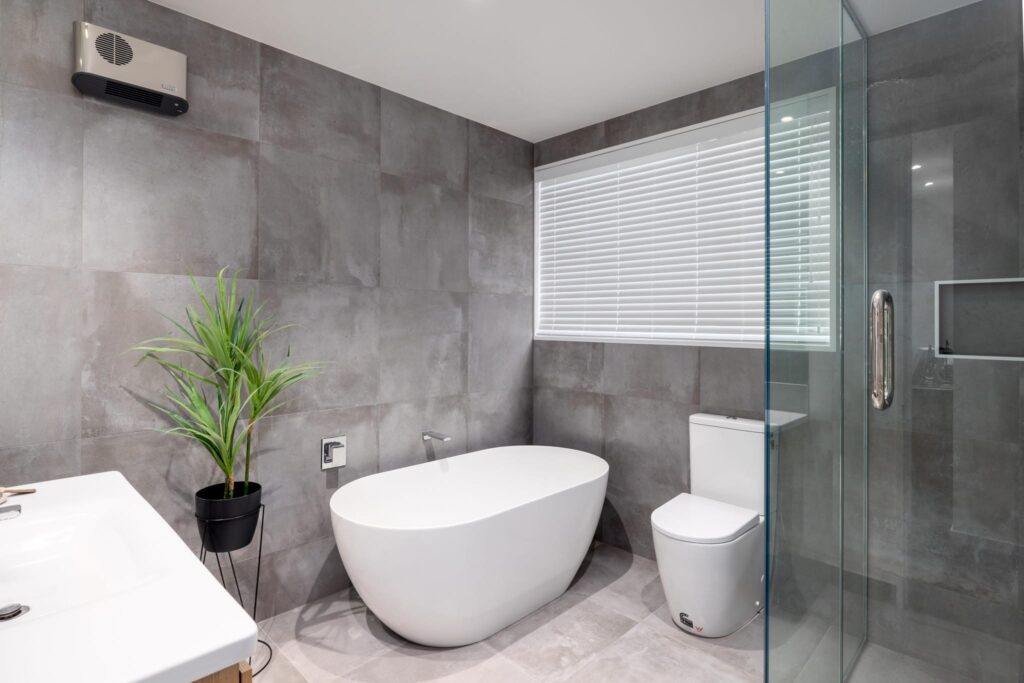 mohs_developments_canterbury_projects_11_ashford_avenue_7 Modern bathroom in a new build home with a freestanding bath and tiled walls, ideal for showcasing modern houses for sale, new homes, and architectural homes.